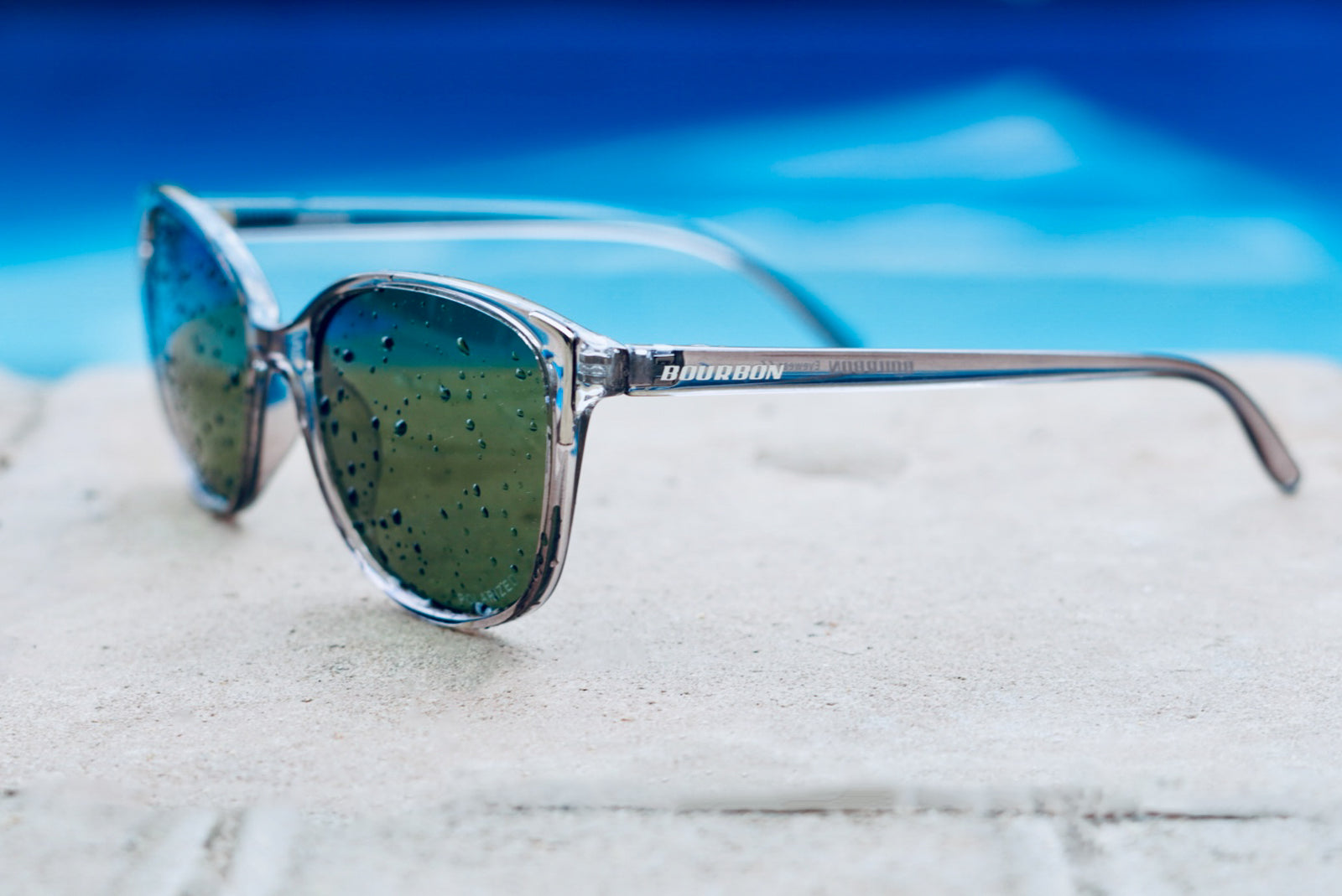 Polarized sunglasses beside a swimming pool